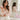 Femme vêtue d’une blouse rose pâle présentant un flacon de parfum dans une salle de bain claire et élégante.