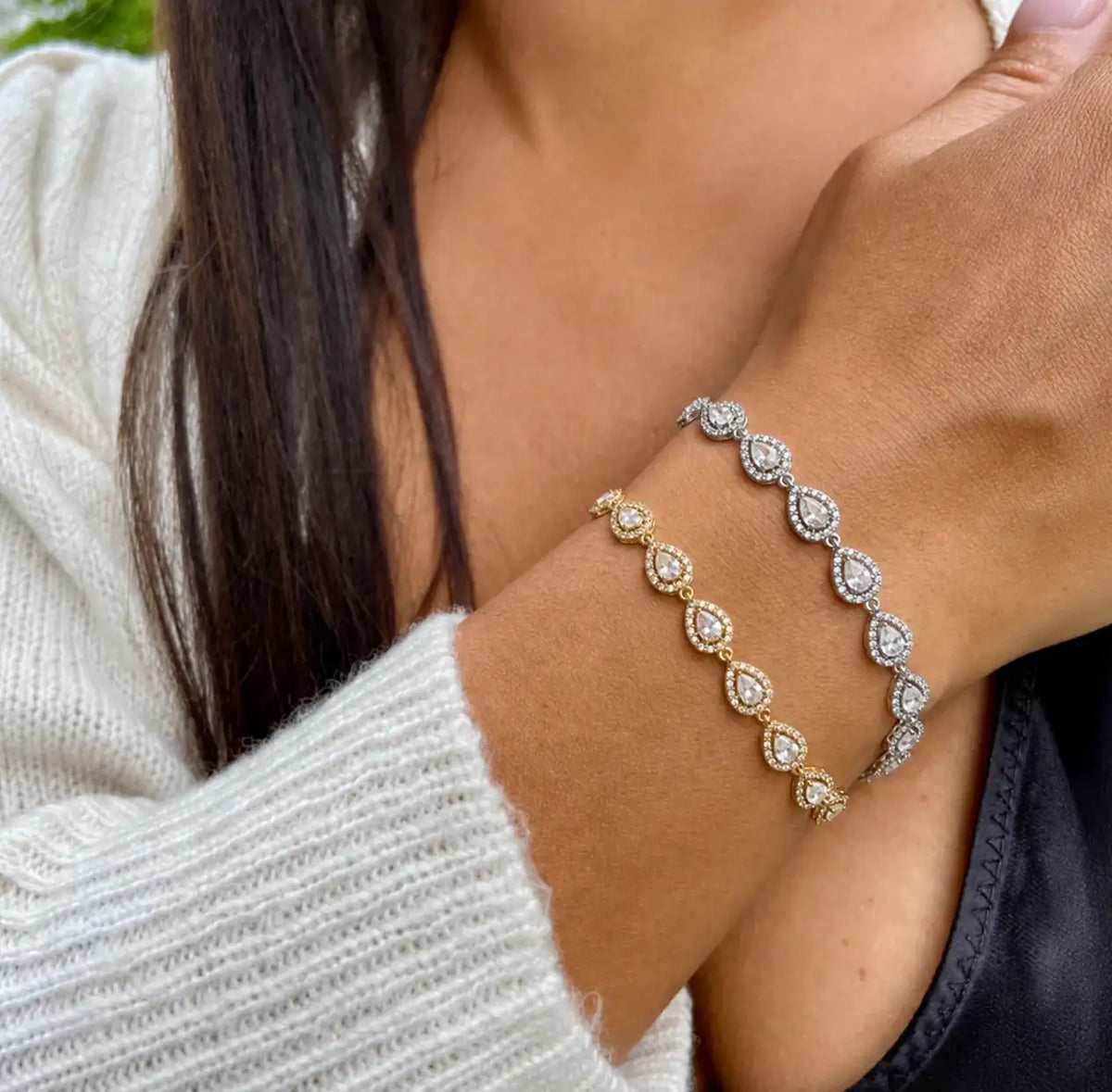 Femme portant deux bracelets tennis superposés, un doré et un argenté, ornés de zircons taille poire